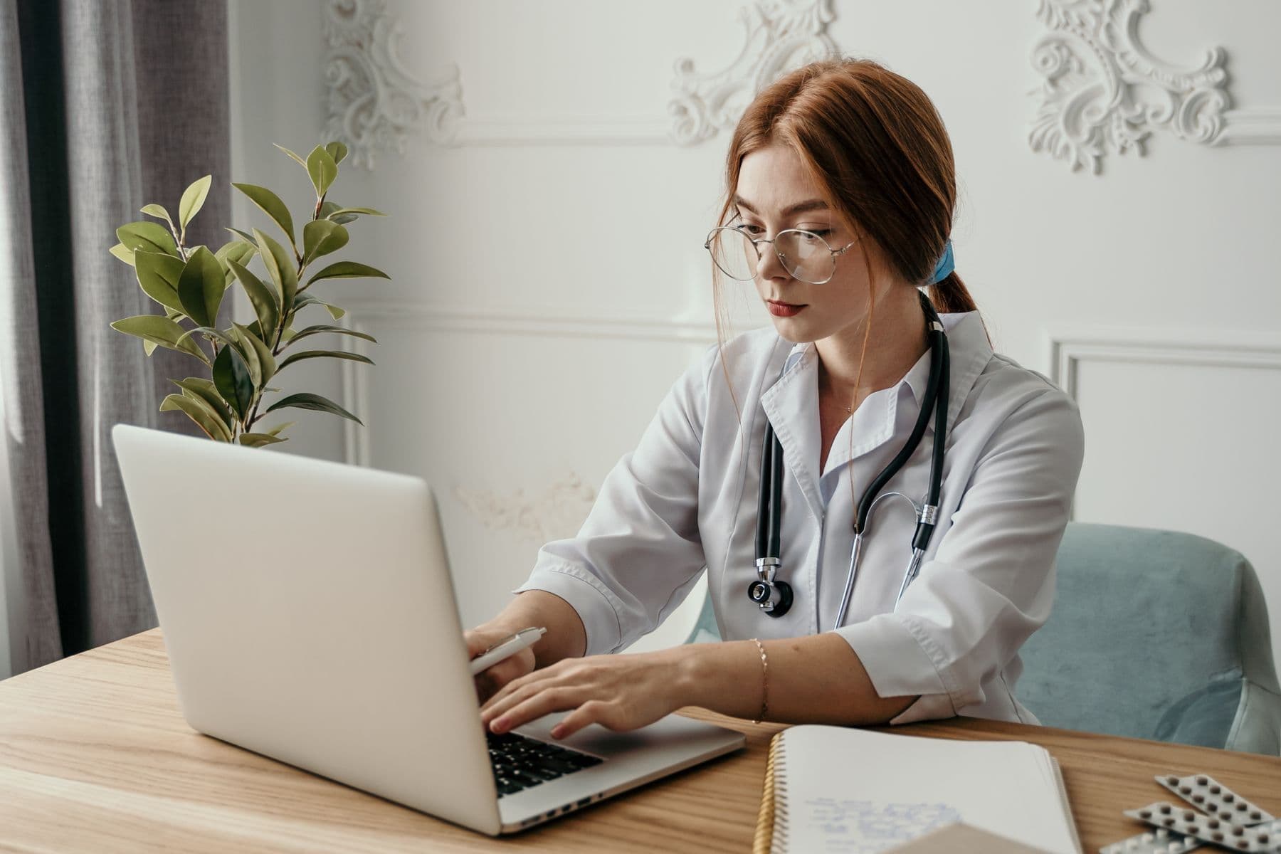 Dokter menggunakan laptop untuk mengelola informasi klinik dan rekam medis elektronik